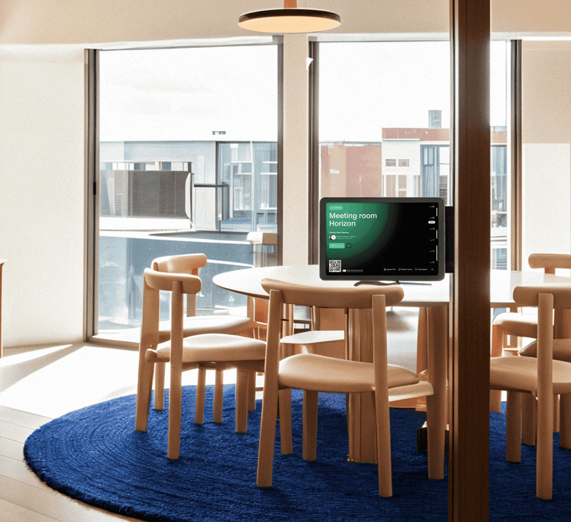 A tablet outside the "Meeting room Horizon" displaying booking information, a QR code for check-in, and a view of a modern meeting space with wooden chairs and a round table.